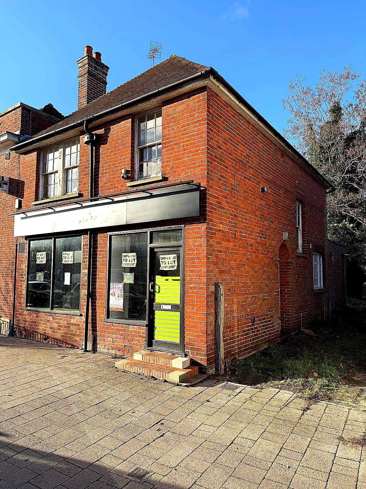 Original premises before refurbishment — brick building with To Let signs